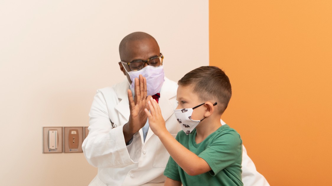 Young boy and provider giving each other a high five